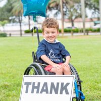 Young boy in wheelchair with thank you sign